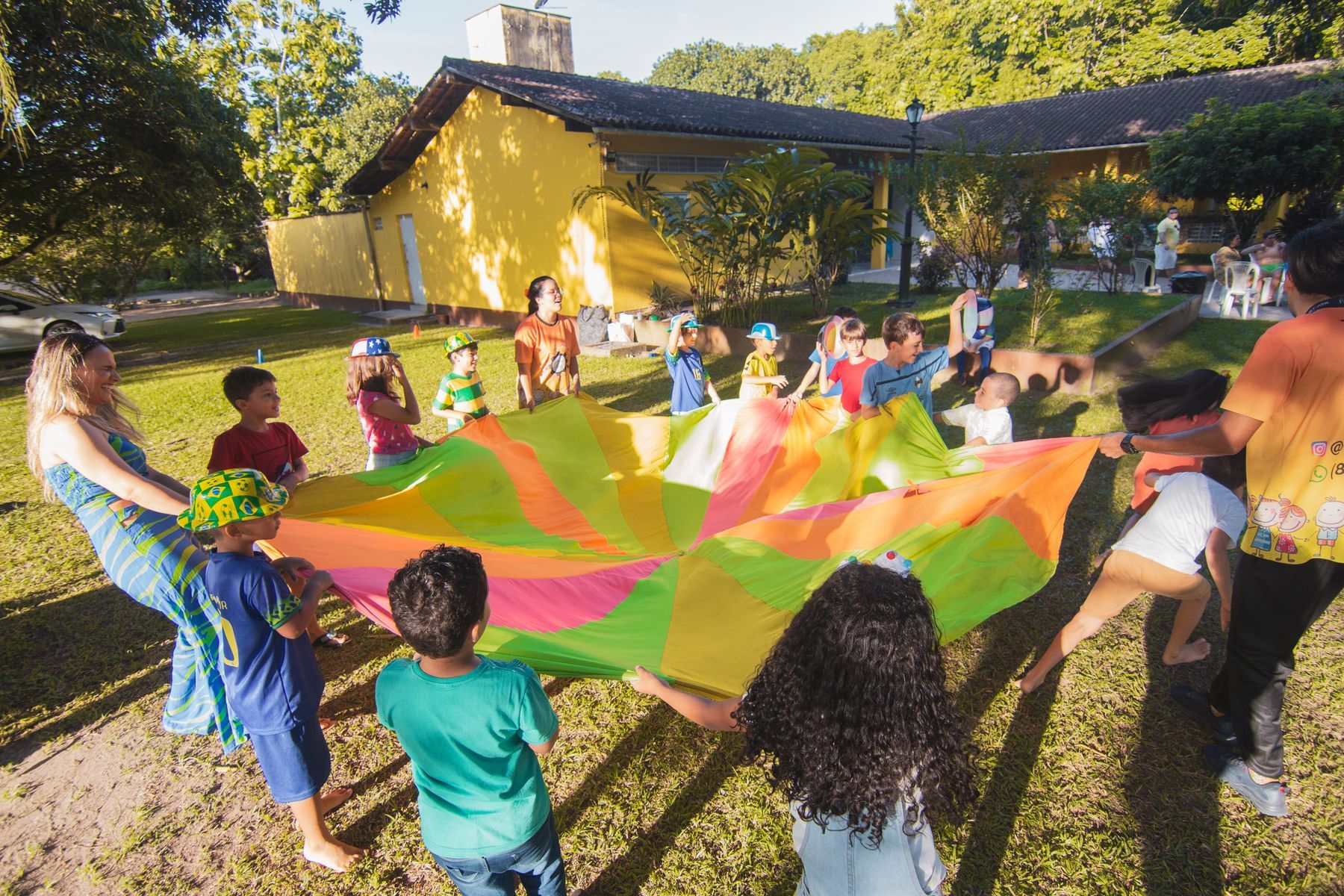 Kids playing with a colourful parachute